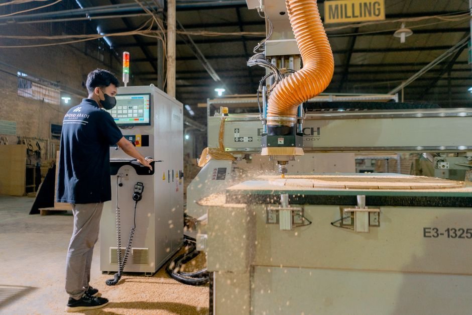 Machinist operating a CNC gear hobber